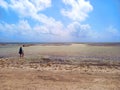 Panorama of the caribbean sea at low tide with tropical clouds and blue sky. Mother and little child look standing on the beach at