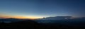 Panorama of the Carpathian mountains at sunset and the lights of the village in the haze, rest and travel in the mountains