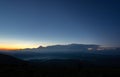 Panorama of the Carpathian mountains at sunset and the lights of the village in the haze, rest and travel in the mountains