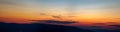 Panorama of the Carpathian mountains at sunset and the lights of the village in the haze