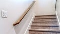 Panorama Carpeted indoor staircase of home with brown handrail against white side wall Royalty Free Stock Photo