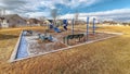 Panorama Childrens playground with neighborhood homes background under cloudy blue sky