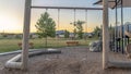 Panorama Childrens playground at a park with swings slides and umbrellas viewed at sunset Royalty Free Stock Photo