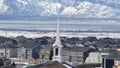 Panorama Church spire against neighborhood homes with snowy mountain and scenic lake view