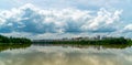 Panorama of city reflection in water under clouds during daytime Royalty Free Stock Photo