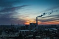 Panorama of city sunset and silhouettes of cranes, high-rise buildings and construction site with smoke Royalty Free Stock Photo