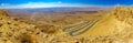 Panorama of cliffs, landscape, and hairpinned road, Makhtesh crater Ramon