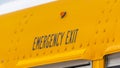 Panorama Close up of the exterior of a yellow school bus with an Emergency Exit sign Royalty Free Stock Photo