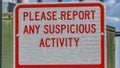 Panorama Close up of a sign that reads Please Report Any Suspicious Activity