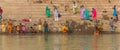 Panorama of colorful people at the stairs to the Ganges river in Varanasi