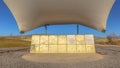 Panorama Concrete rectangular structure under a white canopy against vivid blue sky