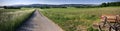 Panorama of country field with a speed bike on a country road Royalty Free Stock Photo