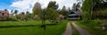 Panorama of countryside. Old two story wooden house by the road.Villa cottage made of dark wood with large terrace and balcony. Royalty Free Stock Photo