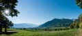 Panorama countryside view with sun shining and fields and forest and mountains in early autumn Royalty Free Stock Photo