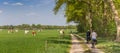 Panorama of a couple riding their bicycle at a dirt road in Overijssel