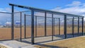 Panorama crop Baseball field dugout with slanted roof and chain link fence on a sunny day Royalty Free Stock Photo
