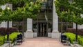 Panorama crop Entrance to a white building with pavement leading to the glass door entryway