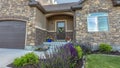 Panorama crop Facade of home with lush yard in front of stone wall and gable roofs