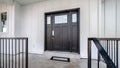 Panorama crop Home entrance with front porch and black front door against white panelled wall