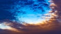 Panorama Defocussed view of a vast blue sky filled with puffy dark clouds at sunset