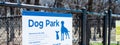 Panorama dog park sign with rules policies on galvanized vinyl-coated chain link fences, steel posts panels at rest area public