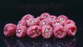 Panorama down at pile of fresh ripe raspberries staffed with jelly on black tray