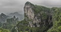 Panorama: Dramatic artistic view of The Tianmen Mountain Peak with a view of the cave Known as The Heaven`s Gate surrounded by th Royalty Free Stock Photo