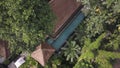 Panorama from drone flight of open swimming pool in L-form tropical spa resort