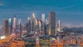 Panorama of Dubai Financial Center district with tall skyscrapers with illumination day to night timelapse.