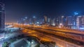 Panorama of Dubai Marina skyscrapers and Sheikh Zayed road with metro railway aerial all night timelapse, United Arab