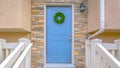 Panorama Entryway of a home with stairs leading to the porch and blue front door