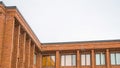 Panorama Exterior of red brick building with flat rooftop and shiny sliding windows