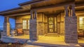 Panorama Facade of an illuminated home against mountain and sky at twilight