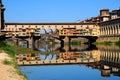 Panorama of the famous Old Bridge Ponte Vecchio and Uffizi Gallery with blue sky in Florence as seen from Arno river Royalty Free Stock Photo