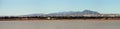 Panorama. Flock of pink flamingos at the Larnaca salt lake, Cyprus. Hills with windmills on background Royalty Free Stock Photo