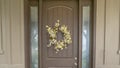 Panorama Flower wreath on a brown front door with sidelights and windows on both sides