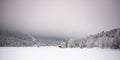Panorama of foggy winter landscape in Austria`s mountains with forest and wooden hut Royalty Free Stock Photo