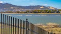 Panorama frame Black metal fence with a lake and grassy shore in the background Royalty Free Stock Photo