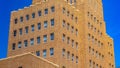 Panorama frame Building exterior with brick wall and rectangular windows against blue sky