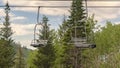 Panorama frame Chairlifts and green trees against cloudy blue sky in Park City Utah in summer Royalty Free Stock Photo