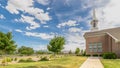 Panorama frame Close up of pathway leading to a church with white steeple under cloudy blue sky Royalty Free Stock Photo