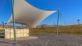 Panorama frame Concrete rectangular structure under a white canopy viewed on a sunny day