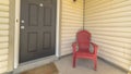 Panorama frame Entrance of a home with gray front door and red wooden chair on the porch Royalty Free Stock Photo