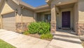 Panorama frame Facade of home with gable roofs over the entrance and garage against blue sky