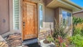 Panorama frame Front porch of house with wooden door and garden