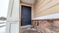 Panorama frame Home entrance with blue panel door and wall with stone bricks and wood siding