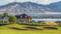 Panorama frame Homes amid a golf course pond and lake with view of towering mountain and valley Royalty Free Stock Photo