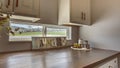 Panorama frame Laundry room interior with cabinets and window above the brown wooden countertop