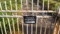 Panorama frame Locked rusty old gate with private property sign and view of lake and mountain