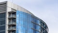 Panorama frame Moden building with glass walls and balconies viewed against cloudy blue sky